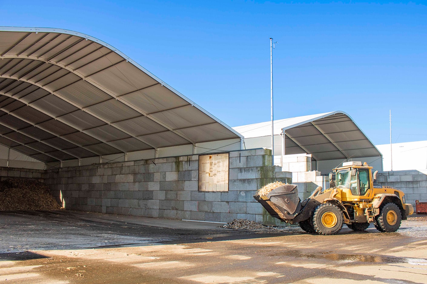 Shovel brengt materiaal onder overkapping Bio Dry BV