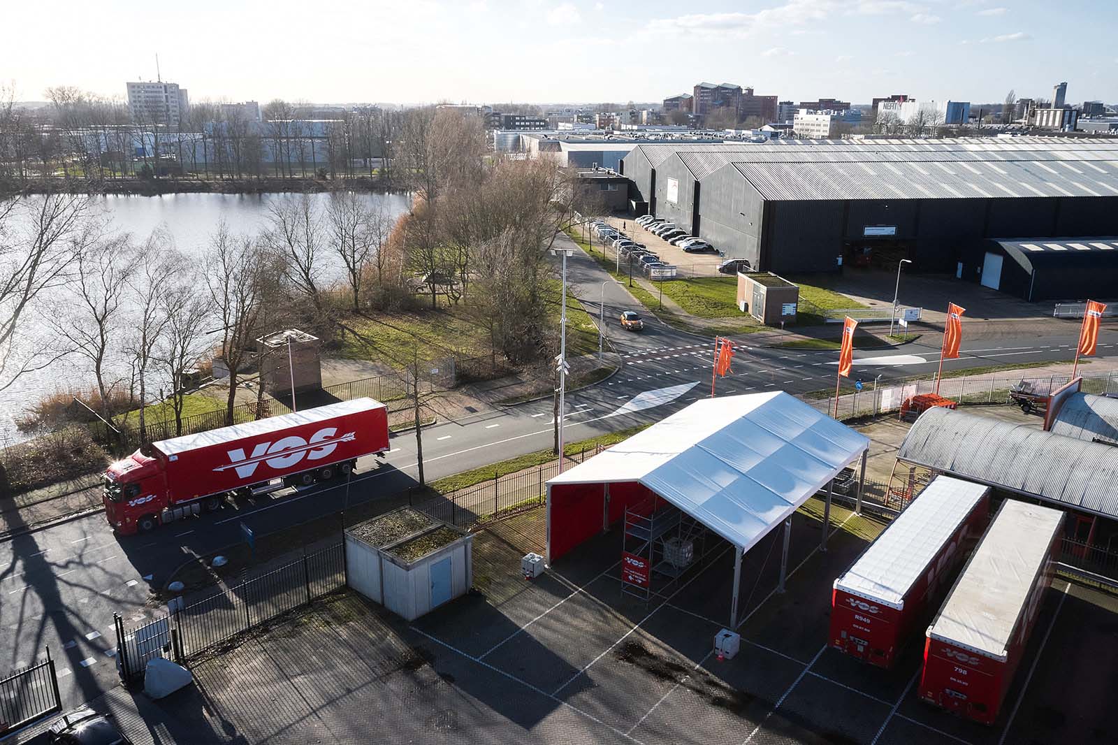 Droneshot locatie Vos Transport met overkapping, vrachtwagen en trailers