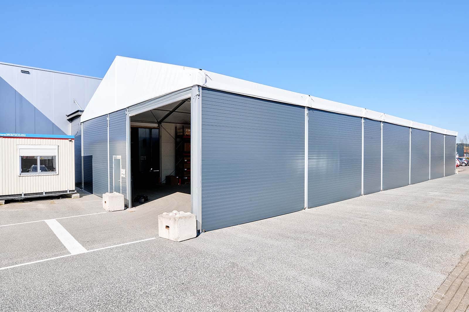 Exterior with roller door in partially insulated tent hall for Itho Daalderop