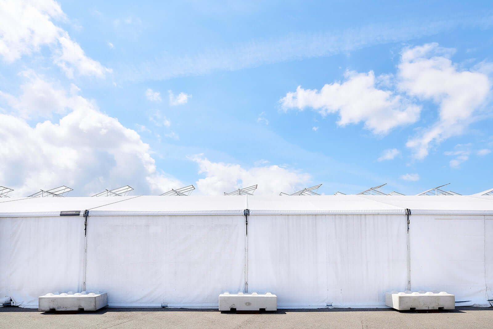 Zijkant zijzeilen en betonblokken als verankering bij opslagtent Valk Horti Systems